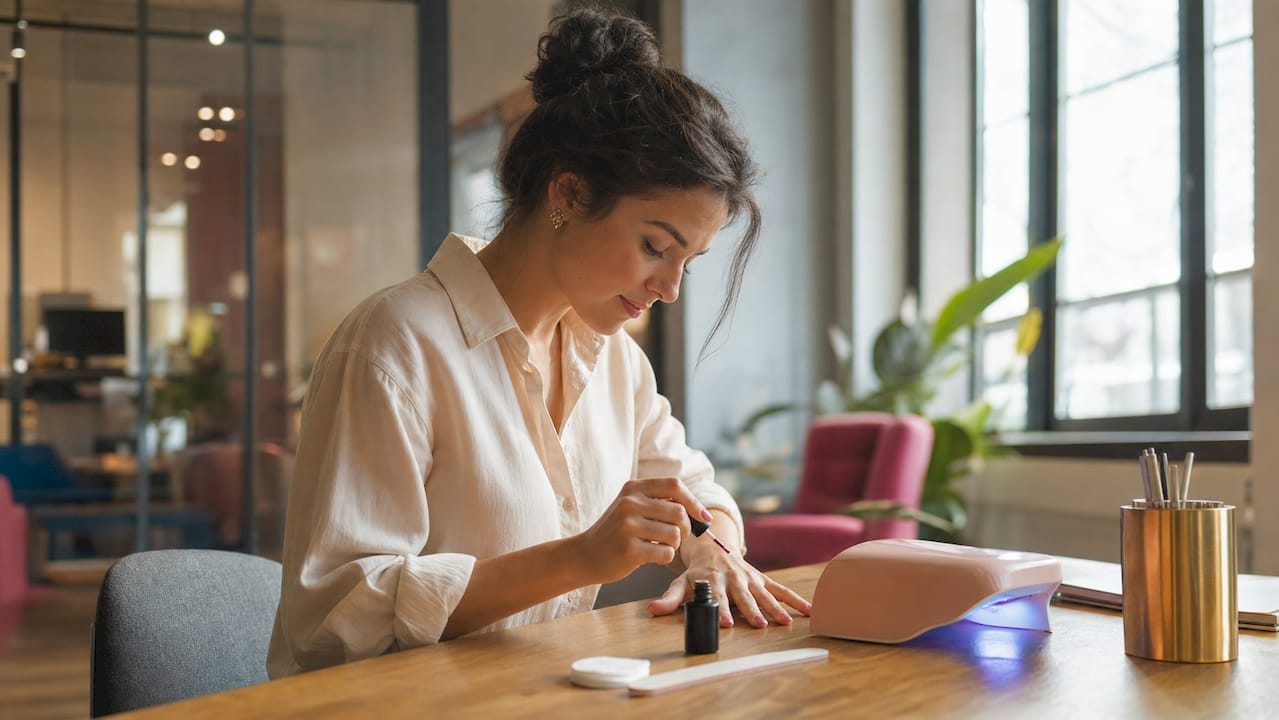 Een vrouw die thuis zelf gelnagellak aanbrengt