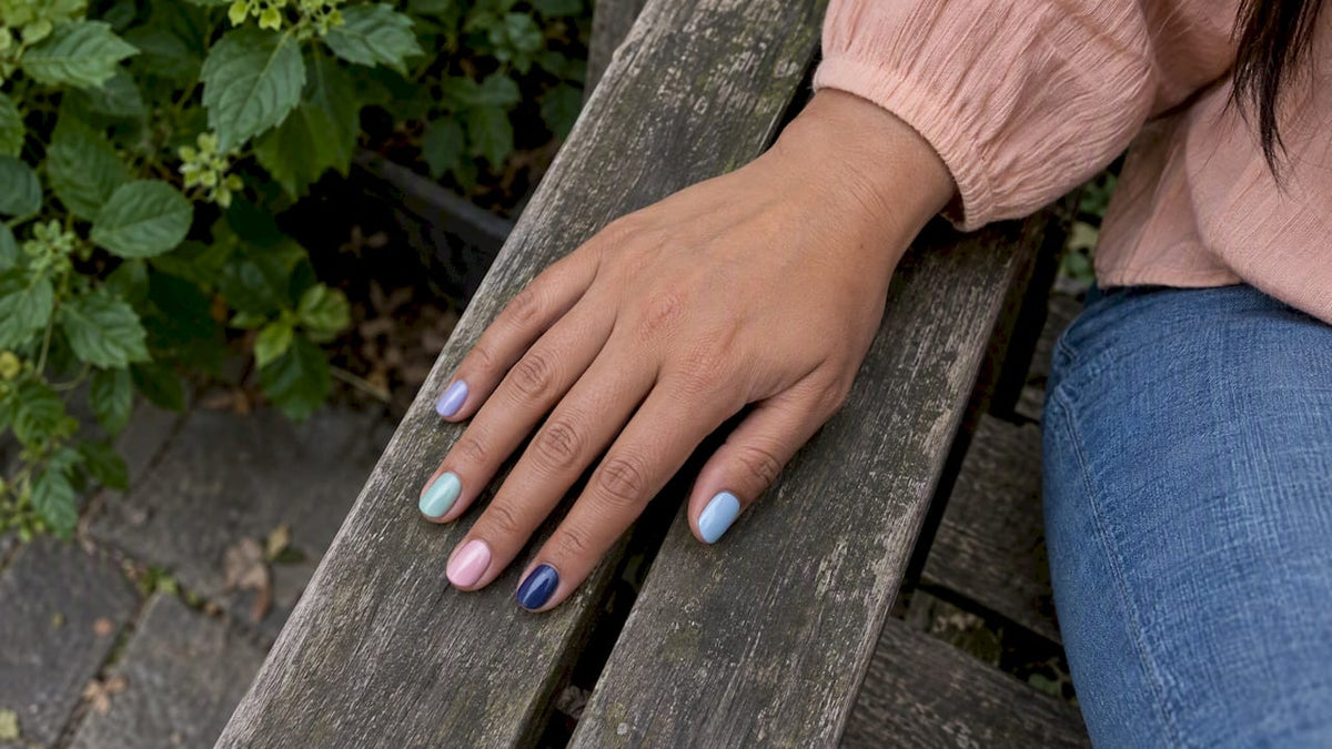 Hand met pastelgellak en een donkerblauw accent